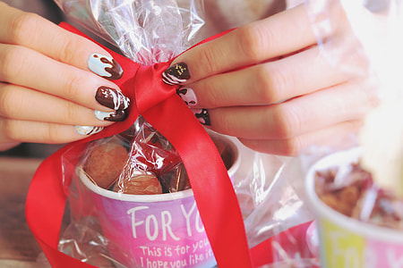 human's hand's tying red ribbon during daytime thumbnail