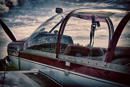 red and gray monoplane under white clouds thumbnail