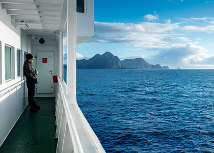 man on boat looking on body of water thumbnail