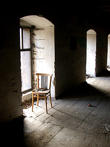 empty brown wooden chair beside glass window inside the building thumbnail