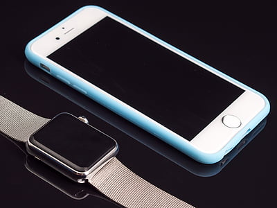 silver iPhone 6 and blue case beside Apple Watch with Milanese Loop thumbnail