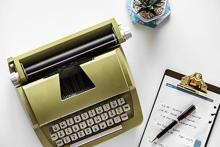 green typewriter on top of table beside clipboard thumbnail