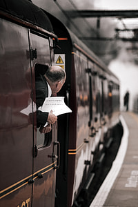 man peeking out of train's window thumbnail