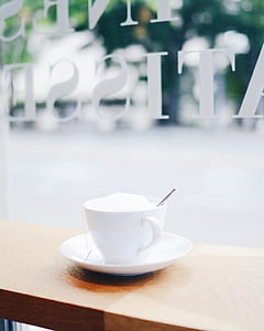 white teacup with saucer filled with tea thumbnail