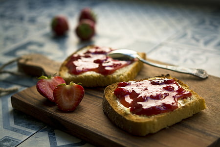 shallow focus photography of loaf bread with strawberry jam on brown wooden chopping board thumbnail