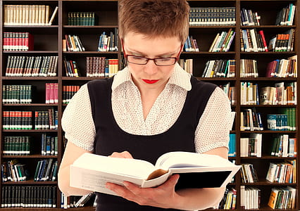 woman reading a book with books in the background thumbnail