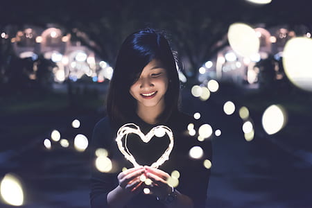 man in black long-sleeved top holding heart lamp thumbnail