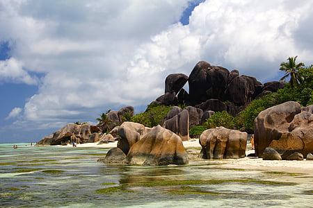 brown and gray rock formation near the body of water thumbnail