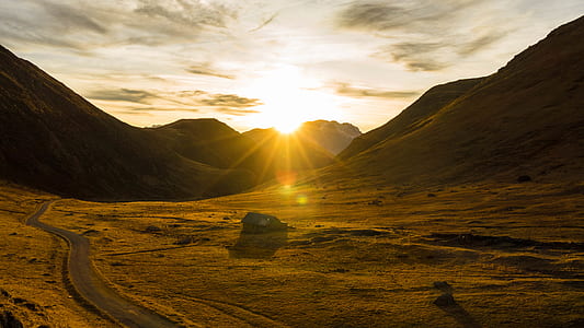 sun rising behind mountains thumbnail