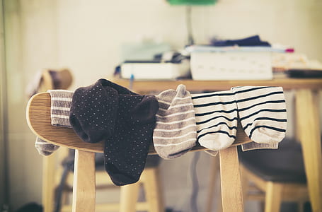 photo of three pairs of assorted-color socks hanging on brown wooden chair thumbnail
