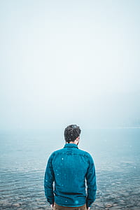 man standing in front of body of water thumbnail