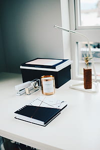 spiral notebook and white stapler on table thumbnail