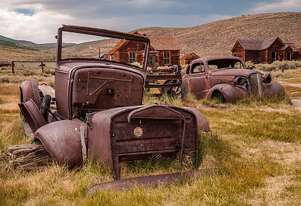 abandoned vehicles near brown house at daytime thumbnail