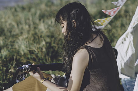 woman playing black guitar thumbnail