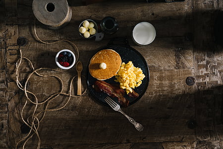 baked pancake with scrambled egg and beacon strip on black ceramic plate thumbnail