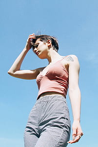 woman wearing pink spaghetti strap top and checkered high-waist pants touching its hair thumbnail