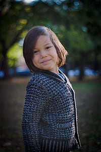 shallow focus photography of child in gray knitted sweater thumbnail