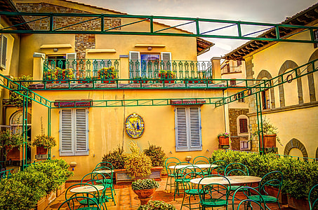 green-and-brown tables beside yellow concrete house thumbnail
