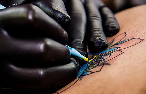 person putting tattoo thumbnail