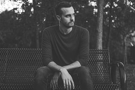 man sitting on bench while looking sidewards thumbnail