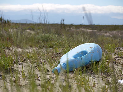 selective focus photography of blue plastic bottle on ground thumbnail