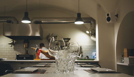 two clear wine glasses on white table thumbnail