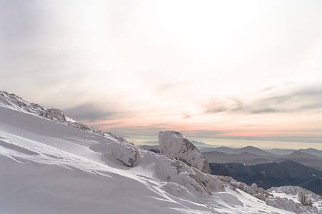 person taking photo of snow-covered mountain during golden hour thumbnail