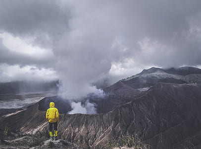 person in yellow jacket facing volcano thumbnail