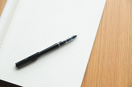 black ballpoint pen on white textile thumbnail