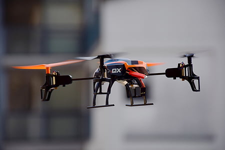 black and orange quadcopter flying thumbnail
