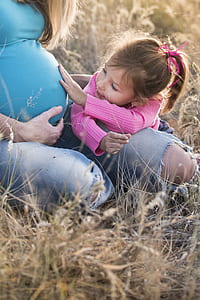 photo of girl touching pregnant woman's womb thumbnail