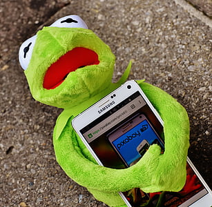 Kermitt the frog plush toy hugging Samsung Android smartphone thumbnail