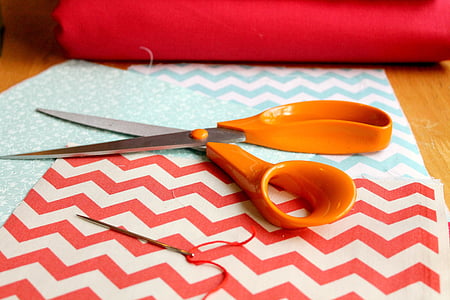 orange scissors on red and white paper thumbnail