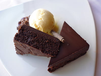 two sliced brownies beside scoop of ice cream on white ceramic plate thumbnail