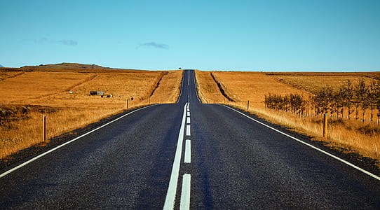 empty road on brown field under blue sky thumbnail