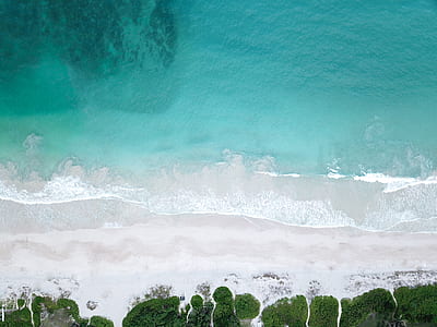 aerial photography of water waves heating seashore thumbnail