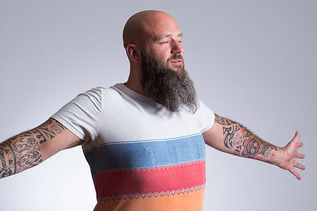 man with tattoos wearing shirt spreading his arms thumbnail