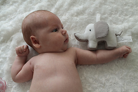 baby lying on white textile thumbnail