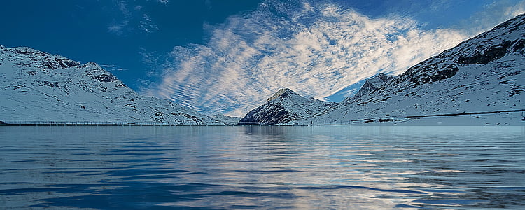landscape photography of ocean surrounded by mountains thumbnail