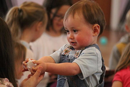 toddler wearing blue crew-neck shirt and blue dungaree facing black haired-woman thumbnail