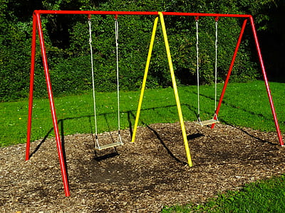 red and yellow swing on playground thumbnail