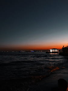lighted gazebo near body of water at night time thumbnail
