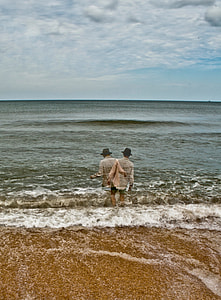 man in beige dress shirt walking beside sea thumbnail