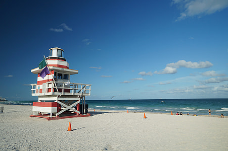 white and orange painted lifeguard cabin near seashore thumbnail