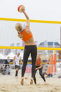 two women playing volleyball outdoors thumbnail