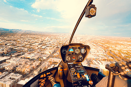 aerial photography of person riding helicopter with a view of urban city thumbnail