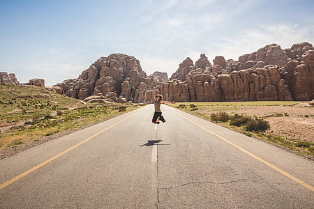woman jumping in the middle of a road thumbnail