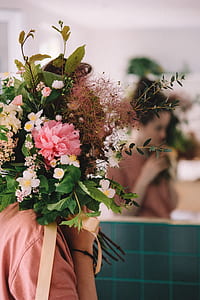 close-up photo of woman covering her face with flowers thumbnail