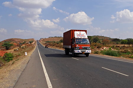 red box truck on black top road during daytime thumbnail