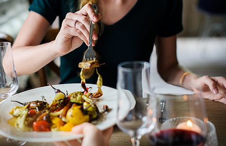 photo of woman wearing black top holding fork with cooked vegetable thumbnail